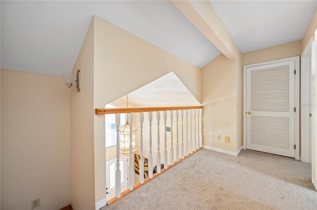 hallway featuring light carpet and vaulted ceiling with beams