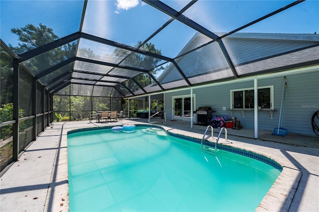 view of pool with grilling area, a patio area, and a lanai