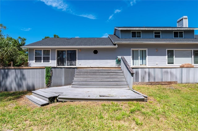 rear view of house with a yard and a wooden deck