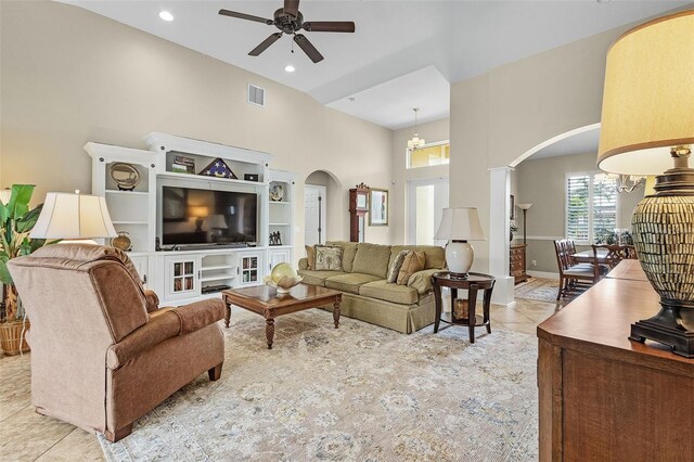 tiled living room featuring built in features, a high ceiling, and ceiling fan