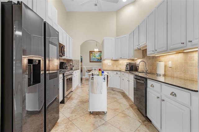 kitchen featuring stainless steel appliances, backsplash, sink, and ceiling fan