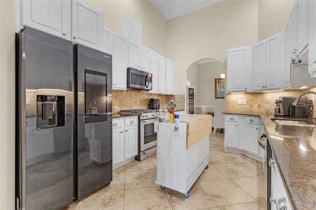 3327 Surfside Blvd, Cape Coral, FL 33914 - kitchen featuring arched walkways, light tile patterned flooring, stainless steel appliances, and a sink
