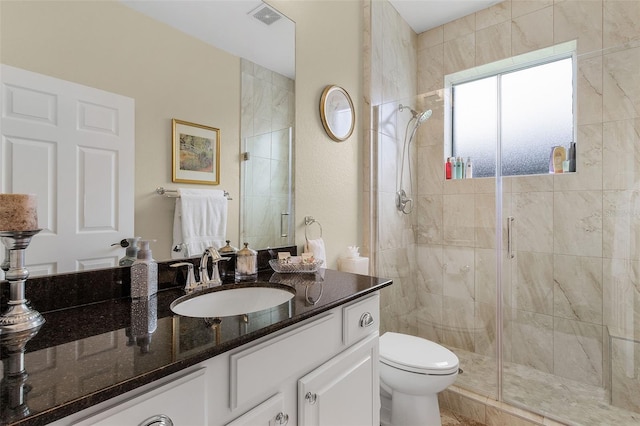 bathroom with a shower with shower door, vanity, and toilet