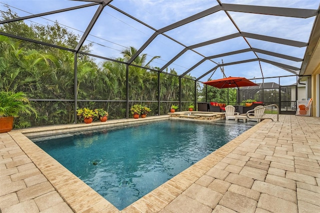 view of swimming pool featuring a patio area, an in ground hot tub, and glass enclosure