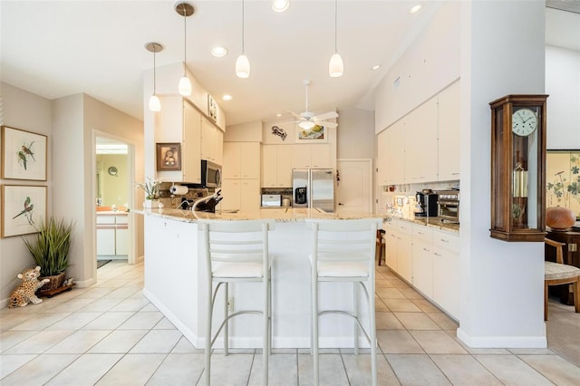 kitchen with white cabinetry, hanging light fixtures, and appliances with stainless steel finishes