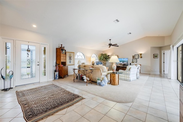 tiled living room with ceiling fan, a wealth of natural light, and lofted ceiling