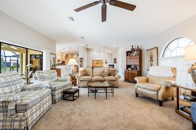 living room featuring light colored carpet, vaulted ceiling, and ceiling fan