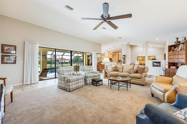 living room with ceiling fan, lofted ceiling, and light tile patterned flooring