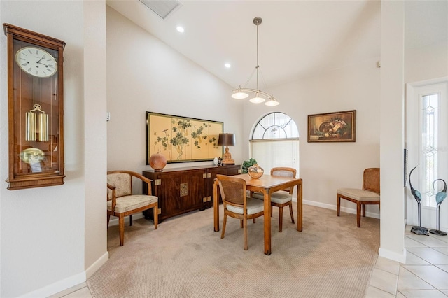 dining space with light tile patterned floors and high vaulted ceiling