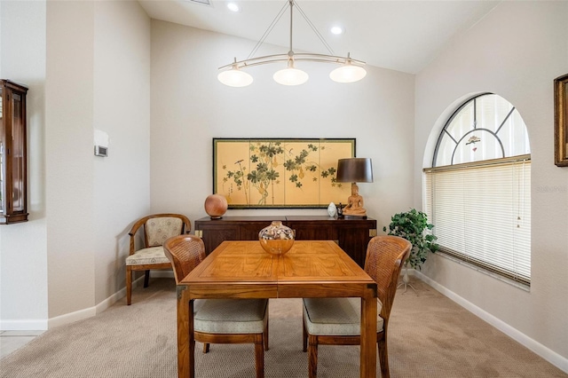 carpeted dining room with lofted ceiling