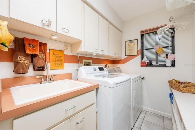 clothes washing area featuring washing machine and dryer, light tile patterned floors, cabinets, and sink