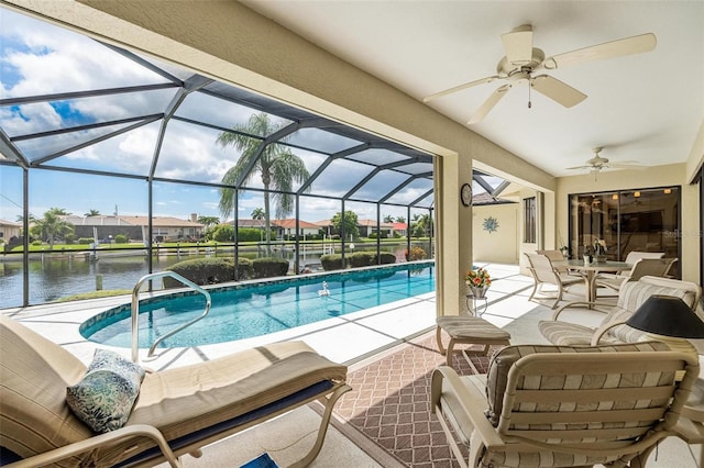 view of swimming pool with glass enclosure, ceiling fan, a water view, and a patio