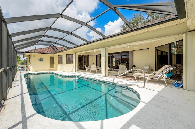 view of pool with glass enclosure, ceiling fan, and a patio