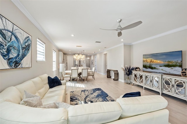 living room featuring ceiling fan with notable chandelier, crown molding, and light wood-type flooring