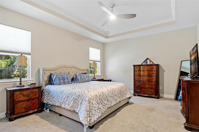 carpeted bedroom featuring ornamental molding, ceiling fan, and a raised ceiling