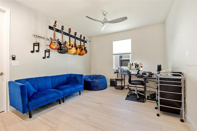 home office with light hardwood / wood-style floors and ceiling fan