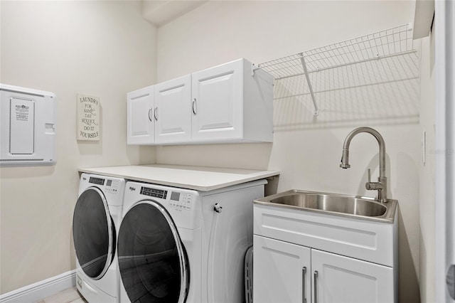 clothes washing area with sink, washer and dryer, and cabinets