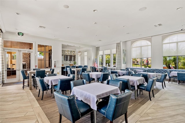 dining area with light hardwood / wood-style floors and french doors