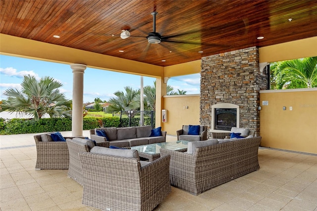 view of patio / terrace with an outdoor living space with a fireplace and ceiling fan