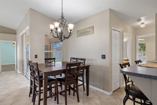 tiled dining area with ceiling fan with notable chandelier and vaulted ceiling