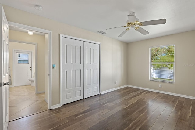 unfurnished bedroom with dark wood-type flooring, a closet, and ceiling fan