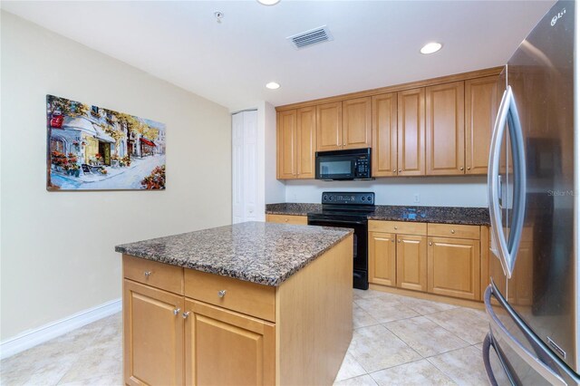 kitchen featuring black appliances, a kitchen island, dark stone countertops, and light tile patterned flooring