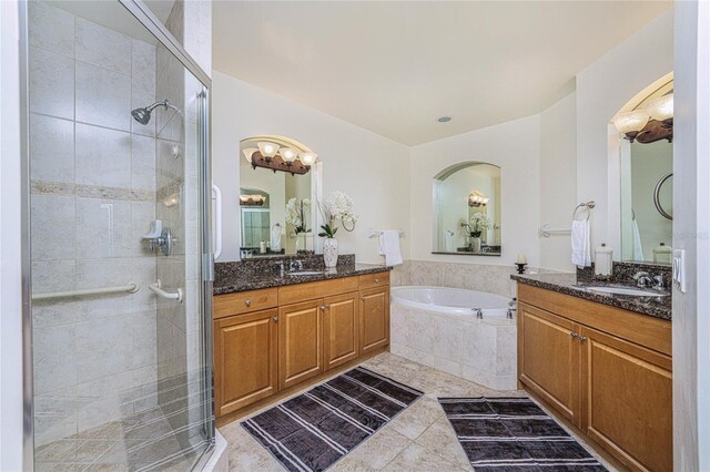 bathroom featuring plus walk in shower, vanity, and tile patterned flooring