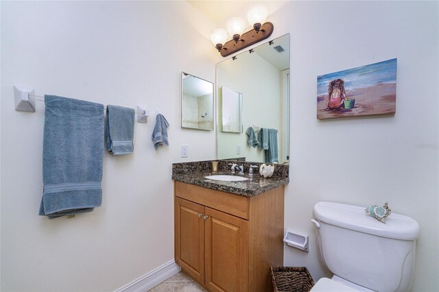 bathroom featuring tile patterned flooring, vanity, and toilet