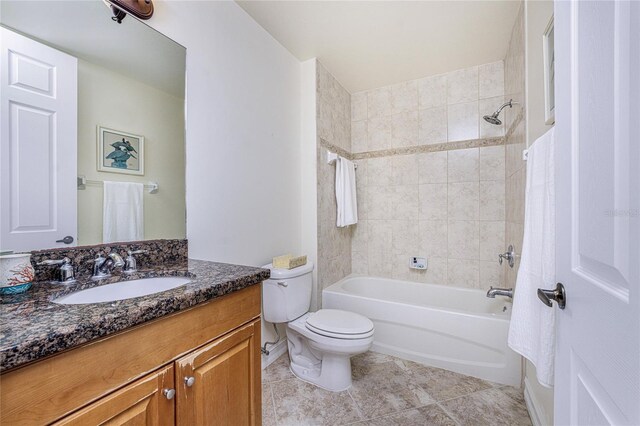 full bathroom featuring tile patterned floors, vanity, tiled shower / bath combo, and toilet