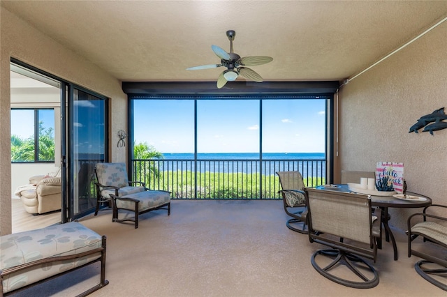 sunroom / solarium featuring ceiling fan, a water view, and plenty of natural light