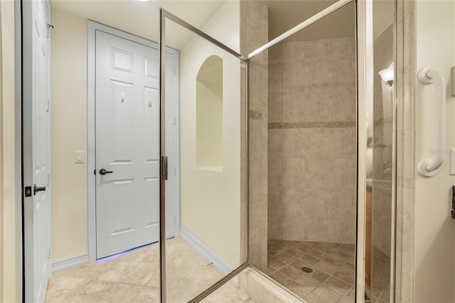 bathroom featuring tile patterned flooring and tiled shower