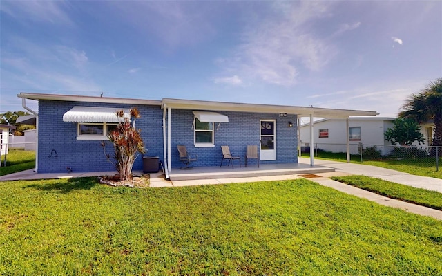 view of front facade with driveway, fence, central air condition unit, a front yard, and brick siding