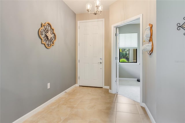 hallway with light tile patterned flooring and a chandelier