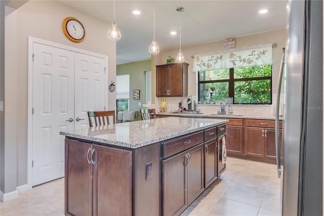 kitchen featuring stainless steel refrigerator, a center island, and tasteful backsplash