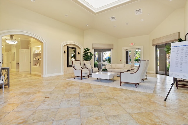 tiled living room featuring high vaulted ceiling and french doors