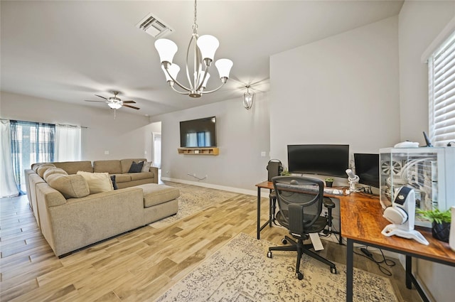 home office with ceiling fan with notable chandelier and light hardwood / wood-style flooring