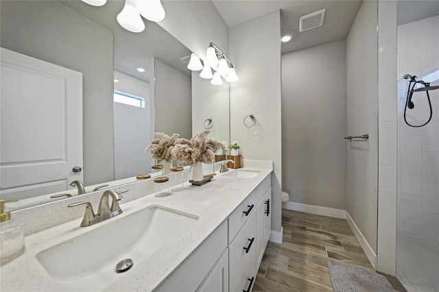 bathroom featuring toilet and double sink vanity