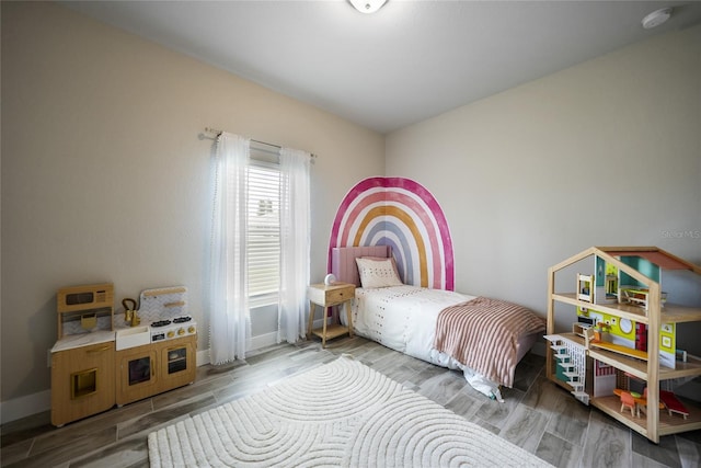 bedroom featuring baseboards and wood finish floors