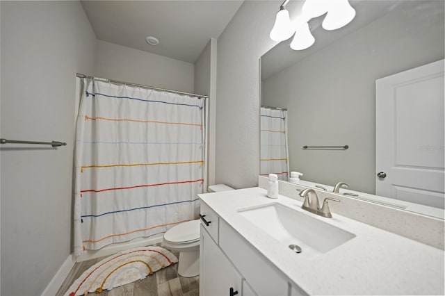 full bath featuring vanity, wood finished floors, toilet, and baseboards