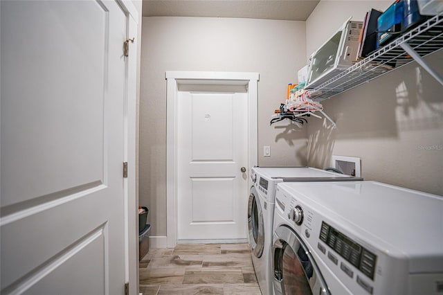 washroom with washing machine and dryer and light hardwood / wood-style floors