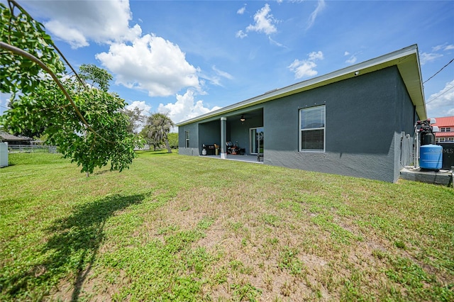 rear view of property featuring a patio, ceiling fan, and a lawn