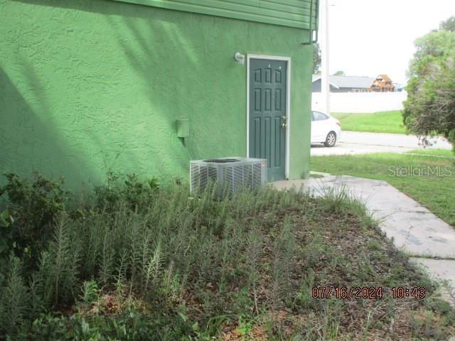 view of exterior entry featuring central air condition unit