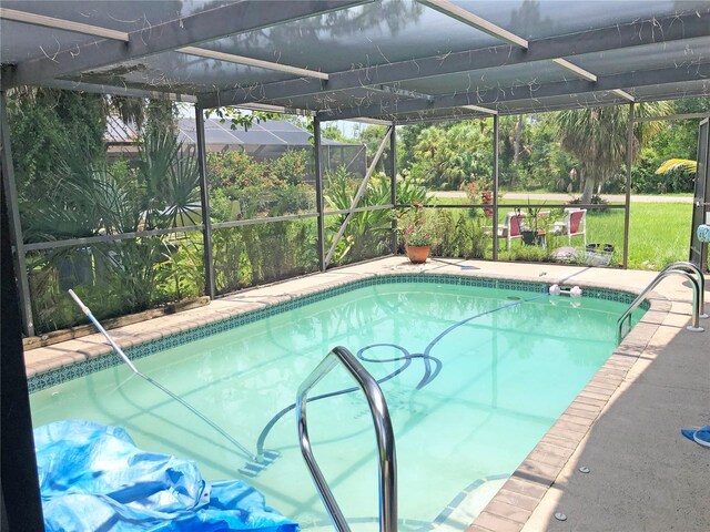 view of swimming pool with glass enclosure