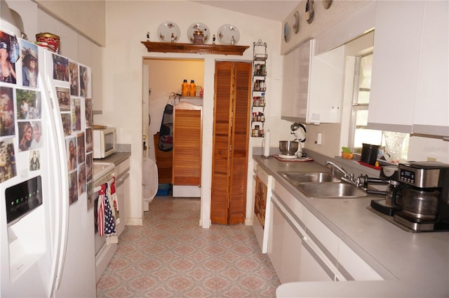 kitchen featuring white cabinetry, lofted ceiling, sink, and white appliances