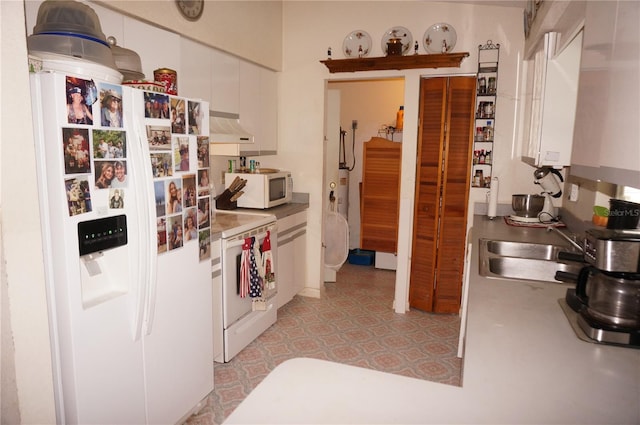 kitchen with white appliances, sink, and white cabinets