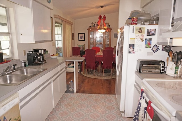 kitchen featuring white cabinets, a wealth of natural light, hanging light fixtures, and sink