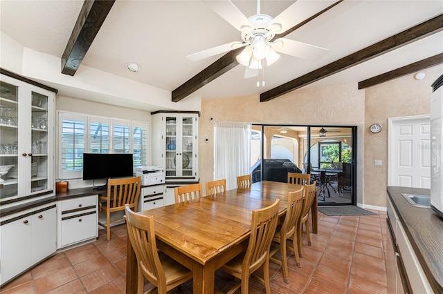 dining space with ceiling fan, beamed ceiling, and tile patterned floors