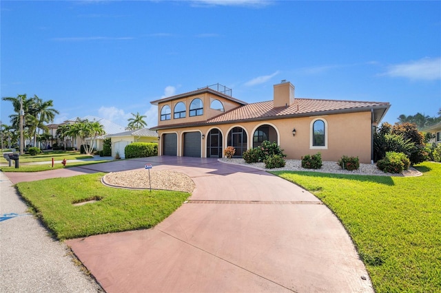 mediterranean / spanish home featuring a garage and a front yard