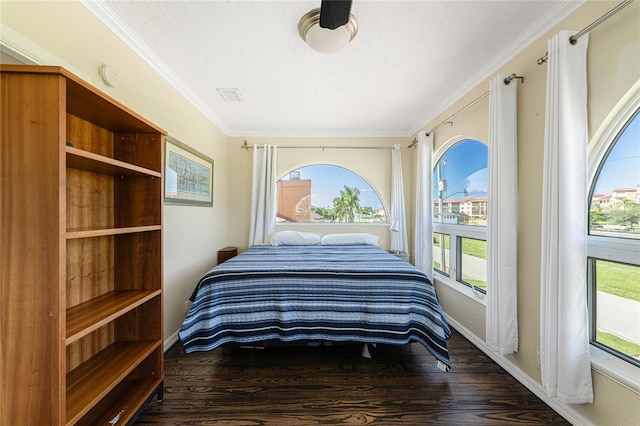 bedroom with dark wood-type flooring, crown molding, and a textured ceiling