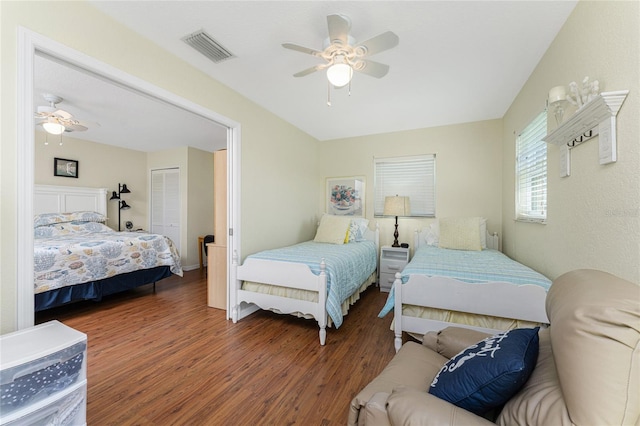 bedroom with dark wood-type flooring, ceiling fan, and a closet